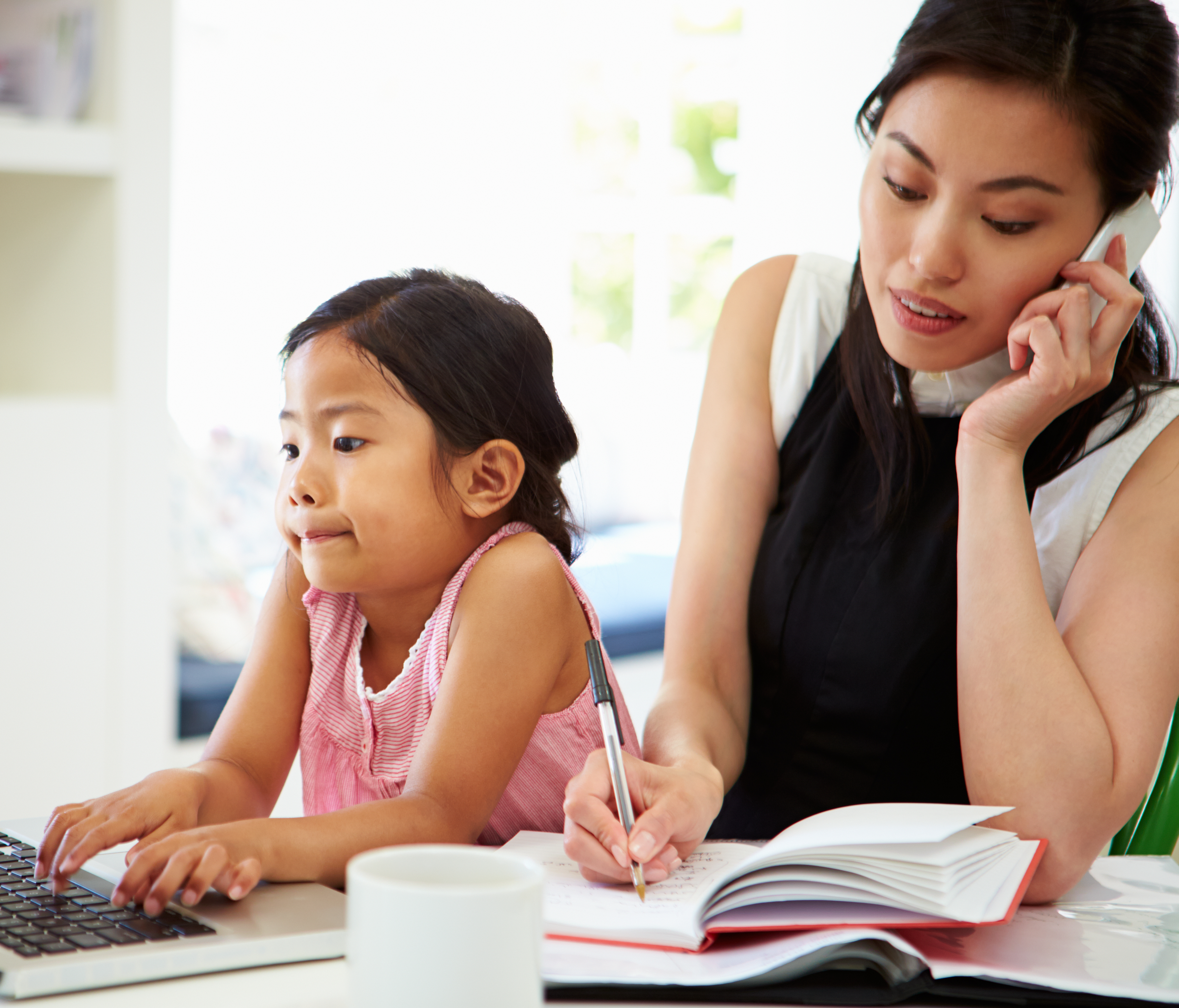 busy mother on phone and young girl child using a laptop