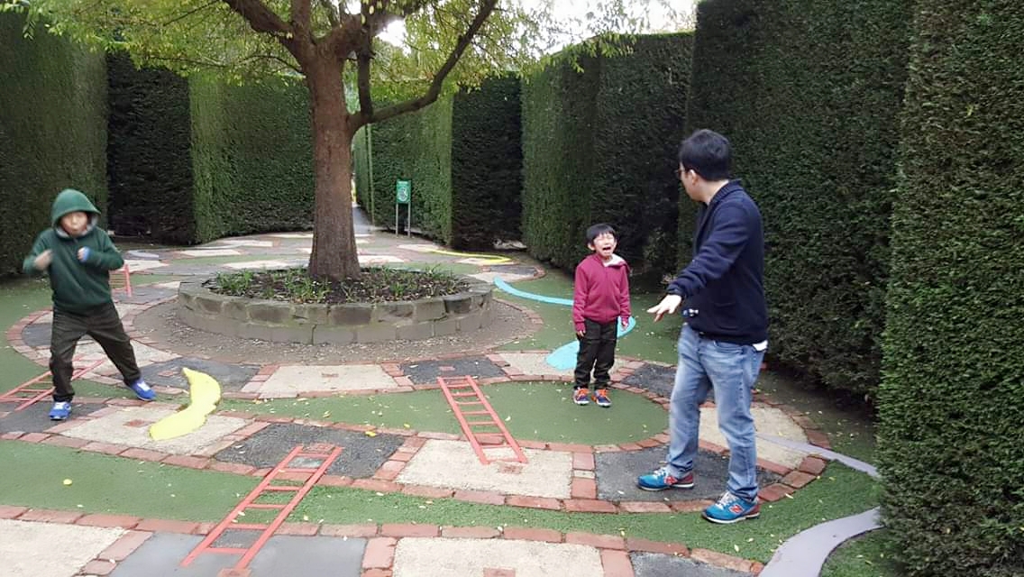 family playing snakes and ladders game in enchanted garden Melbourne