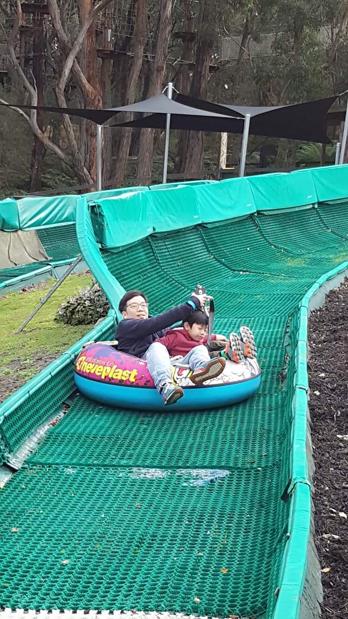 father and son float sliding in enchanted garden melbourne