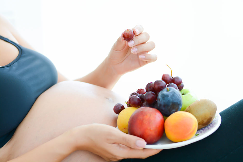 pregnant woman with fruits plate