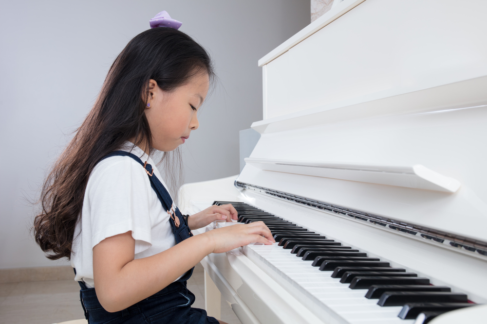 young chinese girl playing the piano