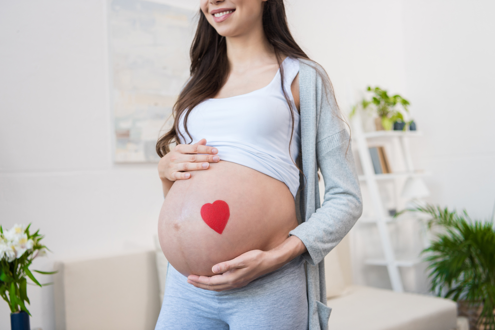 week 19 exposed pregnant belly with heart shaped sticker