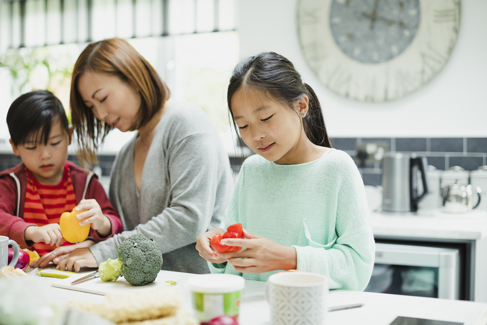 mother and 2 young children bonding over cooking