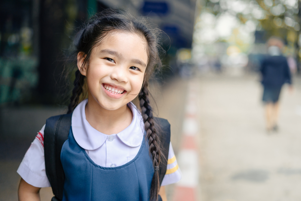 young girl smiling in primary school uniform