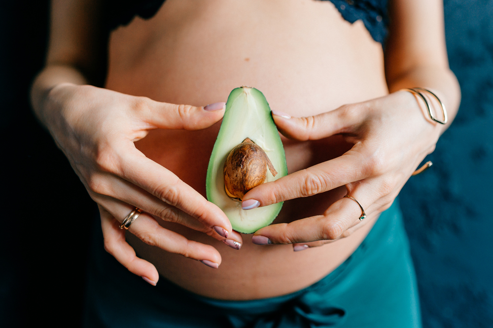week 16 pregnant woman holding avocado