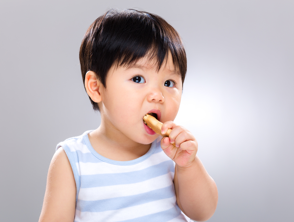 7 to 9 month baby developmental milestones eating a biscuit snack