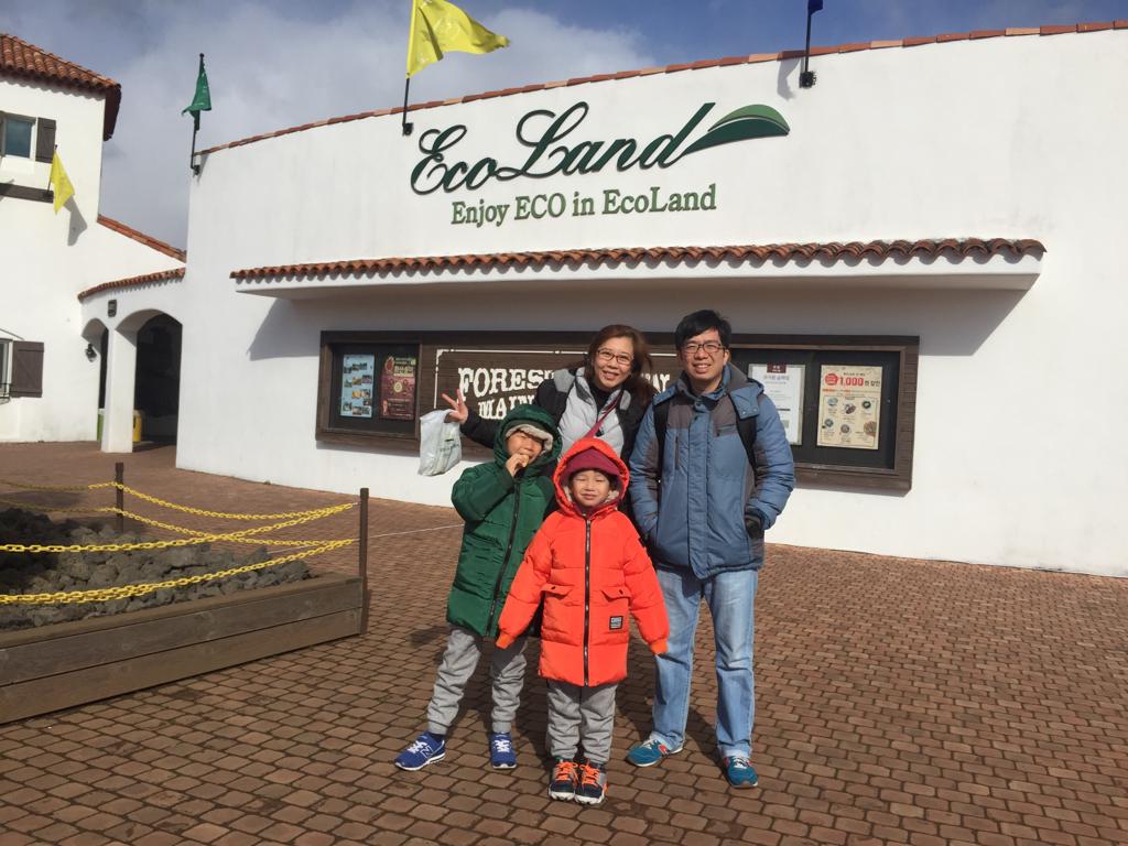 Family photo with Ecoland Jeju sign and entrance